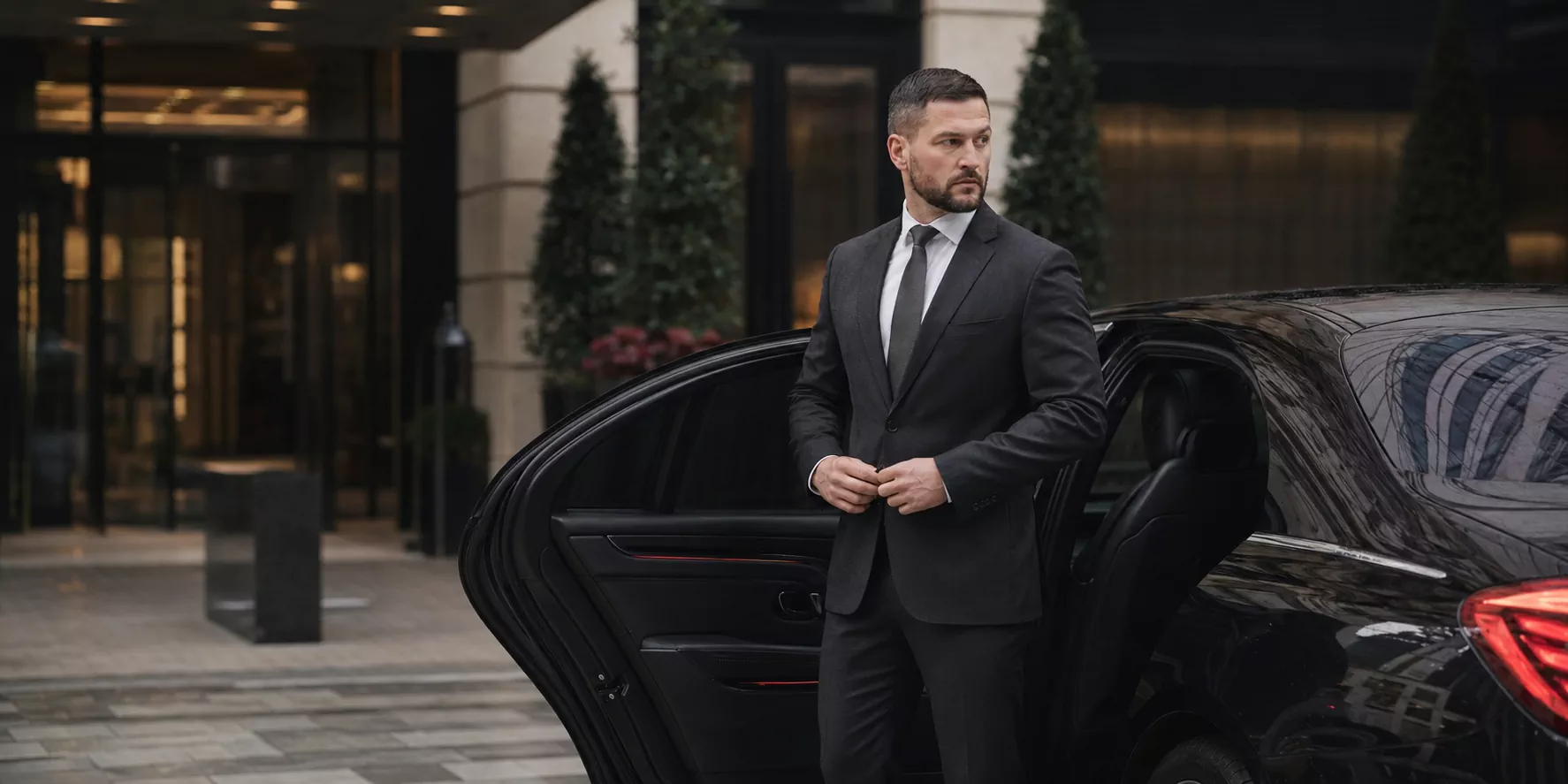 Close protection professional beside a luxury vehicle in London